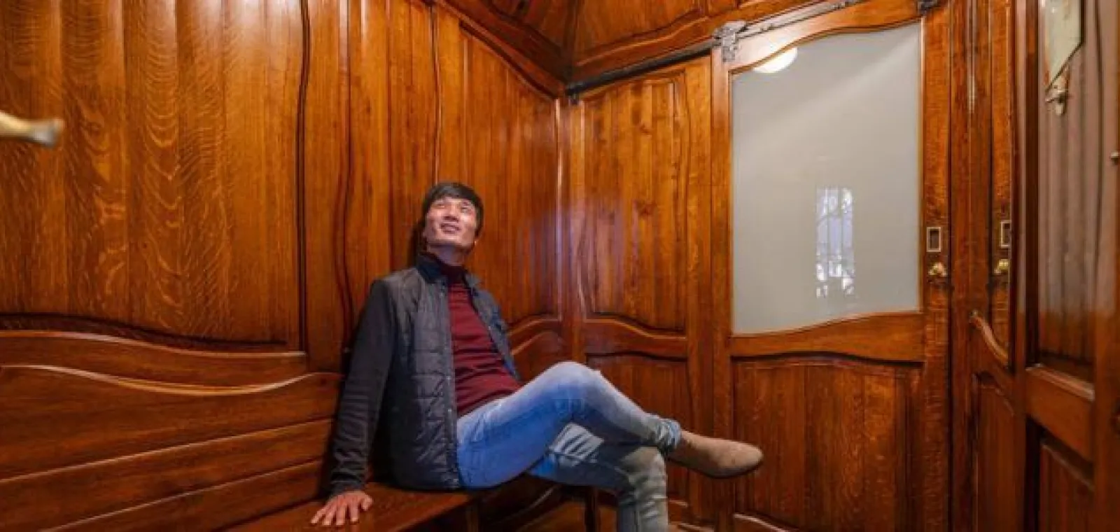 Visitor inside the historic wooden lift